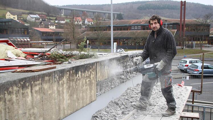 Matthias Hippeli bricht die Blumenkübel auf dem Flachdach ab.