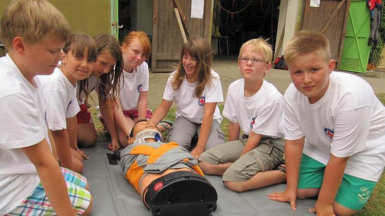 Die Mädchen und Buben der Wasserwacht Jugendgruppe haben der Übungspuppe einen "Stiff-Neck" zur Stabilisierung der Halswirbelsäule angelegt
