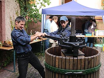 Die Kelter am langen Eisenstab-Hebel zu bedienen, das bleibt den Erwachsenen vorbehalten, weil dazu die Kinderhände zu schwach sind. Fotos: Gerd Schaar