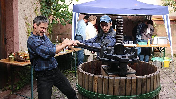 Die Kelter am langen Eisenstab-Hebel zu bedienen, das bleibt den Erwachsenen vorbehalten, weil dazu die Kinderhände zu schwach sind. Fotos: Gerd Schaar