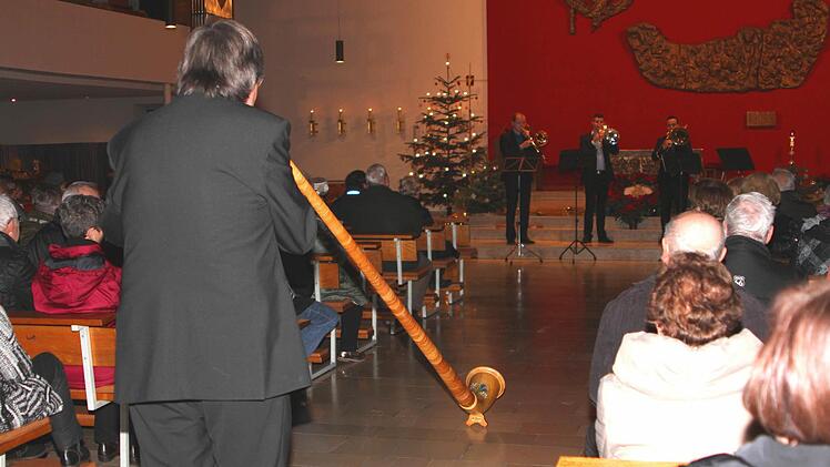 Professor Harry Ries (links) auf seinem Alphorn im Wettstreit mit den drei Posaunen.