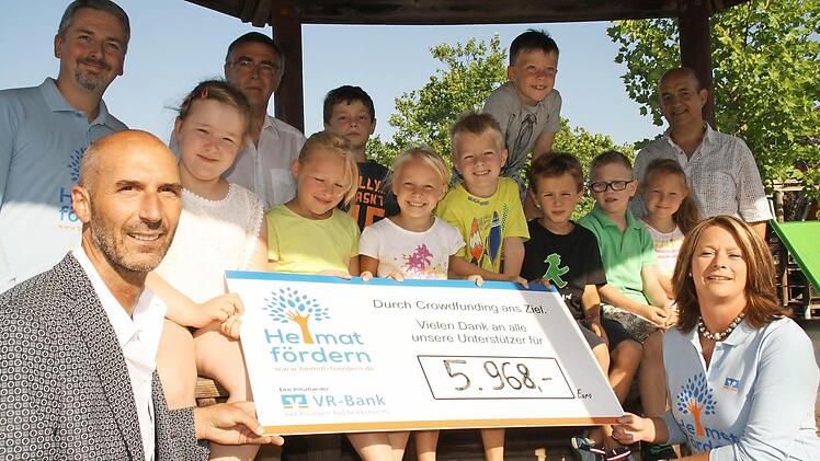 Rund 6000 Euro sind für ein grünes Klassenzimmer an der Sinnberg-Grundschule in Bad Kissingen schon zusammengekommen: Die Schulkinder und Schulleiter Karl-Heinz Deublein freuen sich darüber mit Kirsten Piening (vorne, rechts) und Roland Schmitt (hinten, links, beide VR-Bank) sowie Klaus Lotter (hinten, 2. von links) und Alexander Koller (hinten, rechts) vom Förderverein. Foto: Paul Ziegler