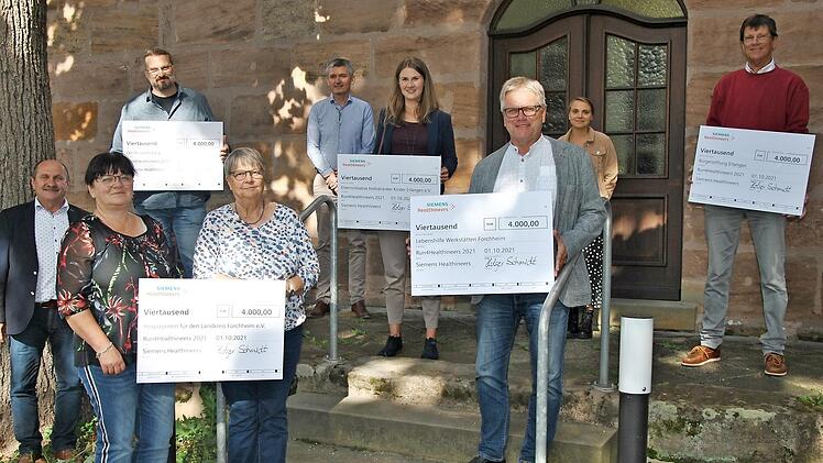 Die Spendenübergabe auf dem Puckenhof (von links): Wolfgang Fees (Siemens-Betriebsrat), Renate Lang (Hospizverein), Martin Burda (Puckenhof), Ulrike Jochemczyk (Hospizverein), Christian Reckziegel (Siemens), Pia Gohla (Elterninitiative krebskranker Kinder), Wolfgang Badura (Lebenshilfe), Annika Dorn (Siemens), Oliver Flotow (Bürgerstiftung Erlangen)