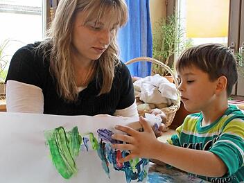 Zusammen mit Erzieherin Manuela Schwendner bringt Nico seine Laterne in die richtige Form.