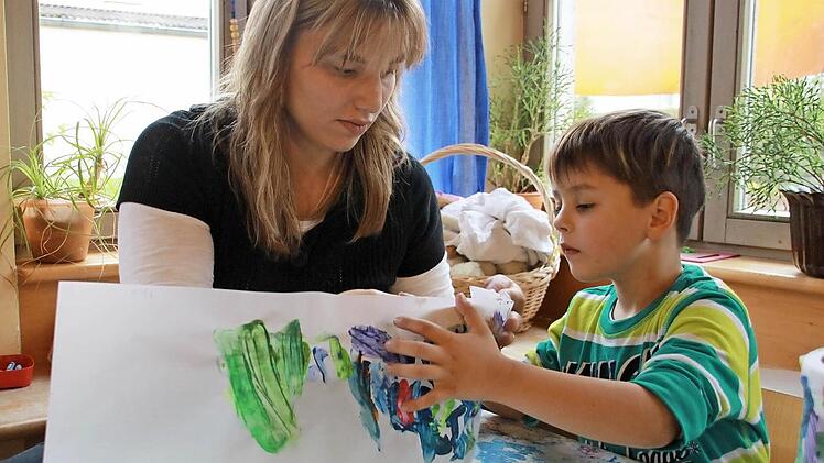 Zusammen mit Erzieherin Manuela Schwendner bringt Nico seine Laterne in die richtige Form.