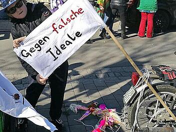 Ein Mitglied des Vereins Rollsport-Freunde Forchheim präsentiert kurz vor dem Start des Umzuges eine Seite des Banners. Zum Ärgernis wurde dann aber die Rückseite des Banners und die hinter dem Mofa hergeschleiften Barbiepuppen. Foto: Rollsport-Freunde Forchheim