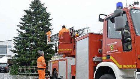 Mit der Drehleiter unterstützt die Feuerwehr Neustadt die Arbeiter beim Anbringen der Festdekoration.