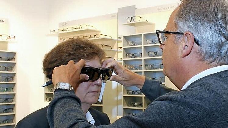 Optiker Siegfried Maertens demonstriert die Wirkung einer Kantenfilterbrille. Foto: Carmen Schwind