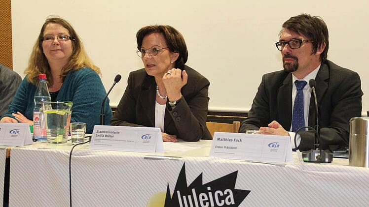 Claudia Junker-Kübert (Vorsitzende des 144. Hauptausschusses des Bayerischen Jugendrings), Emilia Müller (Bayerische Staatsministerin für Arbeit und Soziales, Familie und Integration) und Matthias Fack (Präsident des Bayerischen Jugendrings) auf dem Podium (v. l.) Foto: BJR
