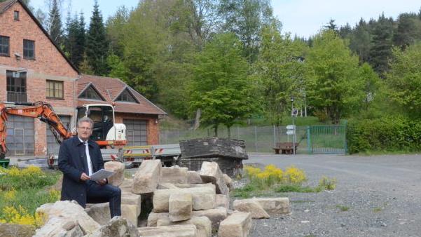 Der Bauhof in Stockheim erh&auml;lt eine neue Lagerhalle. B&uuml;rgermeister Rainer Detsch erkl&auml;rt den Standort um den auch 30 Pkw- und drei Omnibus-Parkpl&auml;tze entstehen werden. Im Hintergrund (links) das bestehende Bauhofgeb&auml;ude in der Mitte die Rentei, die zur Begegnungsst&auml;tte und zum Kulturzentrum saniert wird. Foto: Karl-Heinz Hofmann