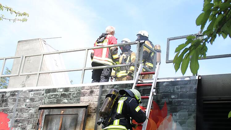 Vier Feuerwehrleute machen sich bereit, in den verrauchten Container zu steigen. Foto: Hilmar Rupper