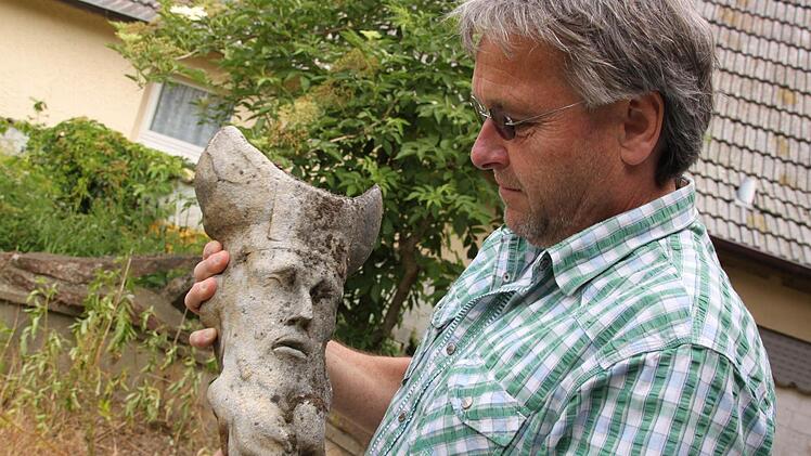 Clemens Muth mit einer Kopie des Sandsteinkopfs des Heiligen Simon - an diesem Stein, der im Freien aufbewahrt wird, prüft er, wie stark eine Reinigung einen Stein schädigt.