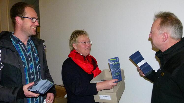 Im Projektreferat des Erzbistums Bamberg nehmen Jochen Högendörfer, Andrea Hofmann und Ulrich Ortner (v. l.) das druckfrische Programmheft entgegen. Foto: Marion Krüger-Hundrup