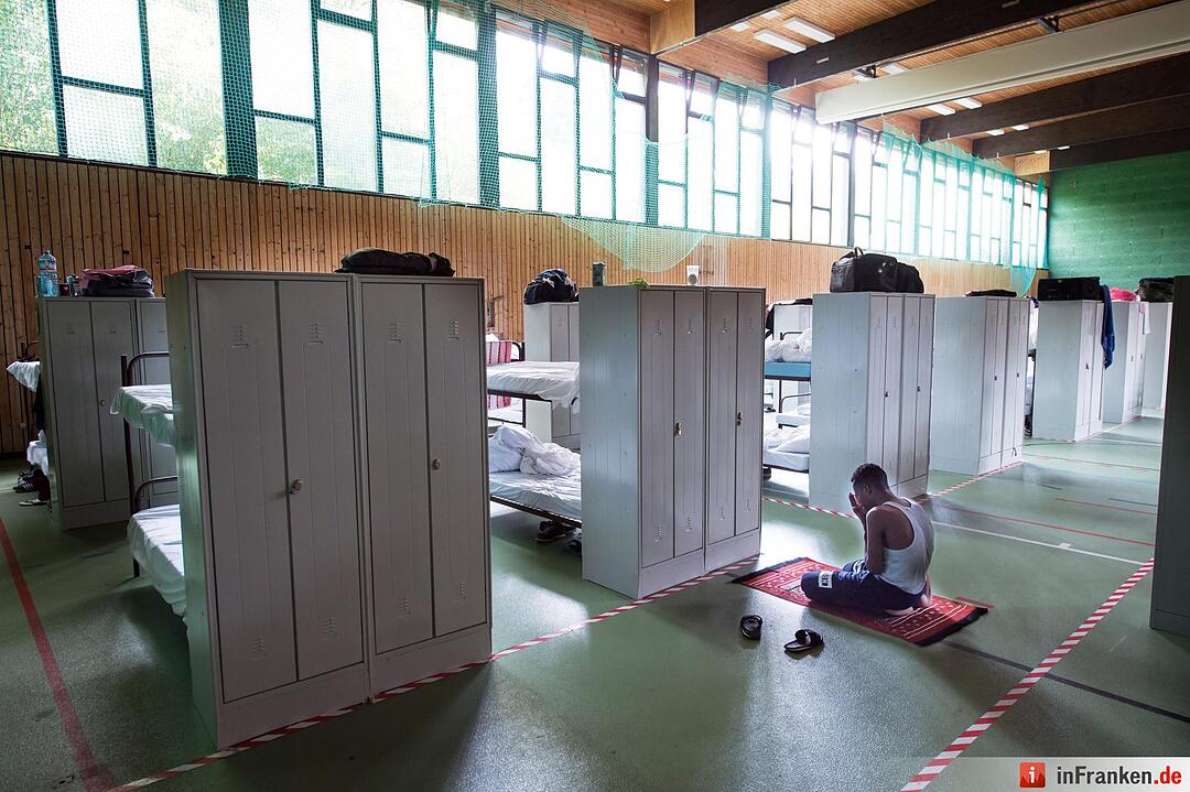 Ein Mann betet am 24.07.2015 in einer zur Flüchtlingsunterkunft umfunktionierte Turnhalle im Münchner Stadtteil Trudering. Das Motiv des dpa-Fotografen Peter Kneffel wurde zum Siegerfoto in der Kategorie "Bayern Land & Leute".