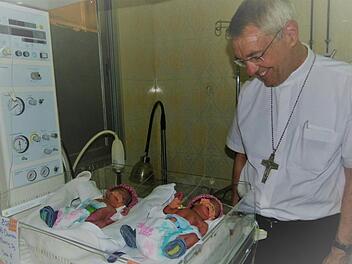 Zwei der Drillingsmädchen im Wärmebettchen: Erzbischof Ludwig Schick freut sich über die neuen Erdenbürgerinnen.  Fotos: Marion Krüger-Hundrup
