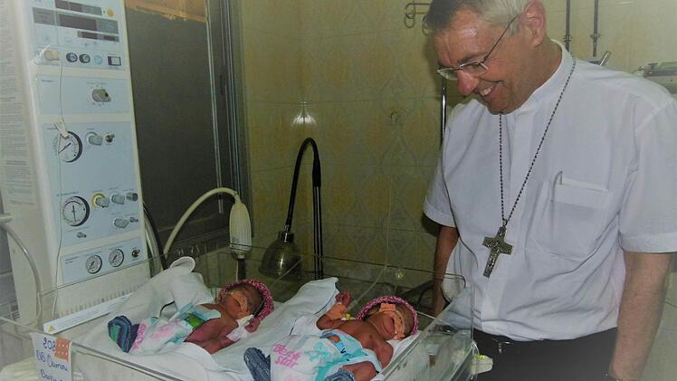 Zwei der Drillingsmädchen im Wärmebettchen: Erzbischof Ludwig Schick freut sich über die neuen Erdenbürgerinnen.  Fotos: Marion Krüger-Hundrup