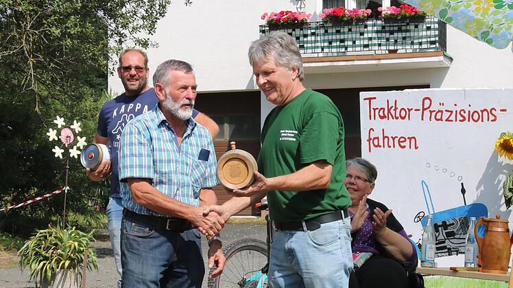 Helmut Reuter (rechts) &uuml;berreicht dem Sieger des Pr&auml;zisionsfahrens, Werner Eller, den ersten Preis: ein Fass Whisky.