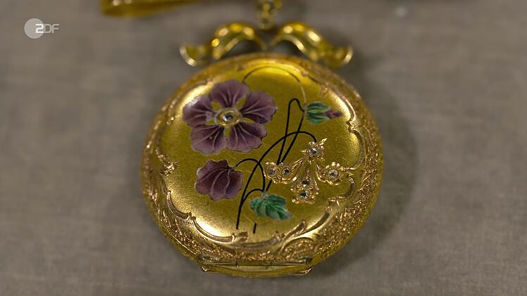Heide Rezepa-Zabel zufolge handelte es sich bei dem Medaillon um eine Mariage aus einem leeren Uhrwerk aus den 1950er Jahren und einer Schleife aus den 1910er Jahren. Für den Schmuck aus 585er und 750er Gold mit feiner Emaille lag der Wunschpreis bei 500 bis 600 Euro. Die Expertin schätzte  900 bis 1.200 Euro. Susanne Steiger zahlte 1.000 Euro.