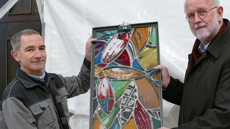 Roland Prahl (links) und Christoph Gatz halten ein Segment des neuen Fensters in den Händen. Es ist zugleich die Lüftungsklappe.