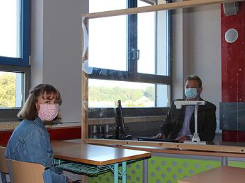 Zum Schulstart sind die Klassenräume im KZG vorbereitet: Thomas Müller (rechts) unterrichtet hinter einer Plexiglasscheibe Anna. Fotos: sgl