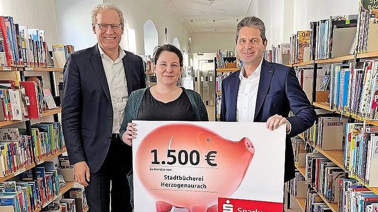 Von links: B&uuml;rgermeister German Hacker, Stephanie Meinel (Stadtb&uuml;cherei) und Roland Stopfer (Leiter der Sparkassen-Zweigstelle Herzogenaurach).