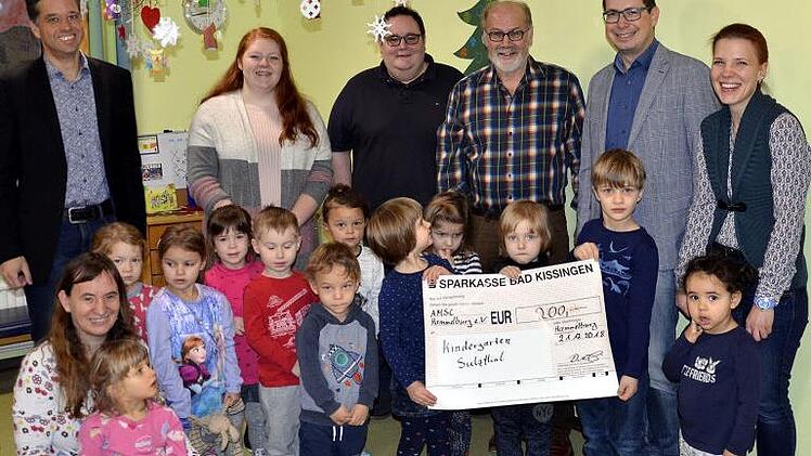 Sulzthals Bürgermeister August Weingart (hinten, 3. v. r.) freut sich zusammen mit den Betreuerinnen des Kindergartens "Gerne Groß" und den Kindern über eine Spende des AMSC Hammelburg. Im Bild Vorsitzender Ralf Deinlein (hinten, 2. v. r.), Sportleiter Florian Arand (hinten, links) und Rallye-Organisationsleiter Sven Hochwimmer (hinten, Mitte).