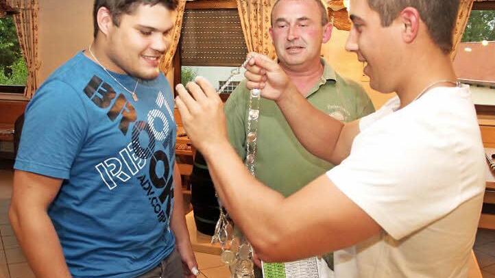 Vorgänger Florian Feiler legt dem neuen Aischer Fischerkönig die Kette um. Foto: Johanna Blum