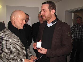Matthias Emmer, Vorstand des Diakonischen Werkes Coburg, zeichnet Dieter Schwämmlein mit dem Kronenkreuz in Gold der Diakonie aus. Foto: Martin Koch