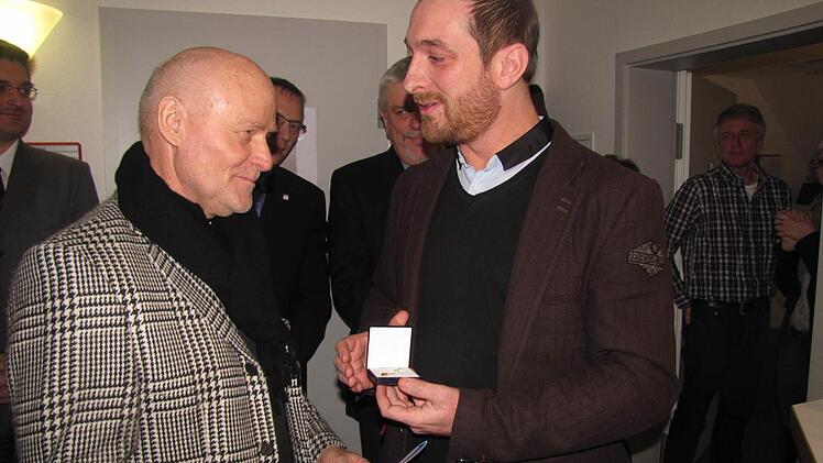 Matthias Emmer, Vorstand des Diakonischen Werkes Coburg, zeichnet Dieter Schwämmlein mit dem Kronenkreuz in Gold der Diakonie aus. Foto: Martin Koch