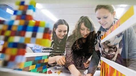 Bianka (17), Ina (18) und Helena (17) kleben die letzten Plättchen ihres Boden-Mosaiks an. Sie bauen eine quadratische Kirche nach dem Vorbild eines Kölner Gotteshauses, das aus den 1950ern stammt.