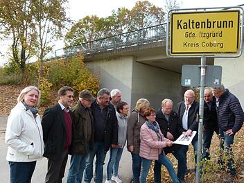 Dieter Scherbel (Dritter von rechts) und Bürgermeister Werner Thomas (Vierter von rechts) erläutern die Pläne der Zufahrt zum Neubaugebiet "Kapellenfeld" durch den Brückenneubau. Foto: Lothar Weidner