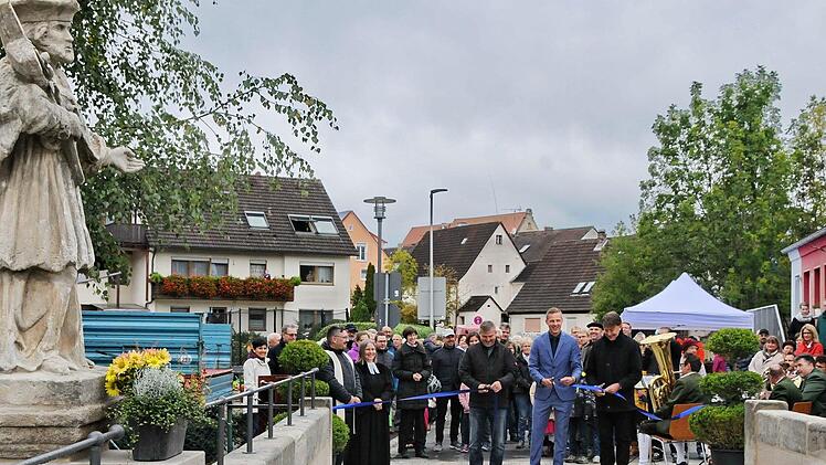 Bürgermeister Holger Bezold und Vertreter der ausführenden Unternehmen schneiden das Band durch und geben die Nepomukbrücke offiziell für den Verkehr frei.  Foto: Karl Heinz Wirth