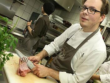Marco Schneider legt Hand an ein Lamm-Carrée. Zu Hause betätigt er sich schreibend.  Foto: Barbara Herbst