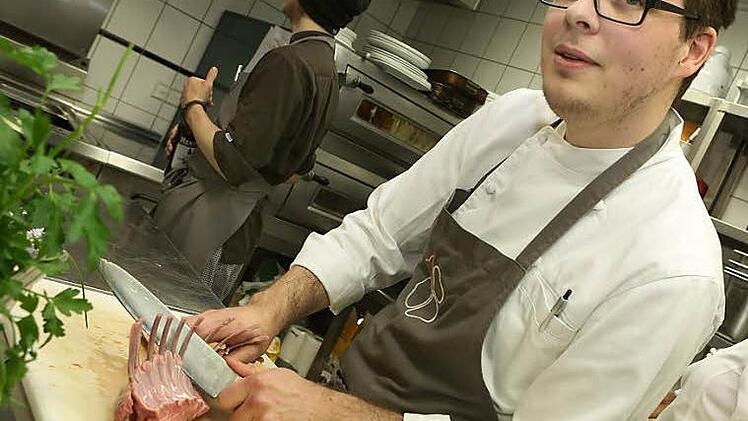Marco Schneider legt Hand an ein Lamm-Carrée. Zu Hause betätigt er sich schreibend.  Foto: Barbara Herbst