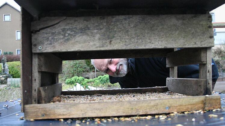 Klaus Petter guckt in sein Vogelhäuschen. Foto: Sabine Paulus