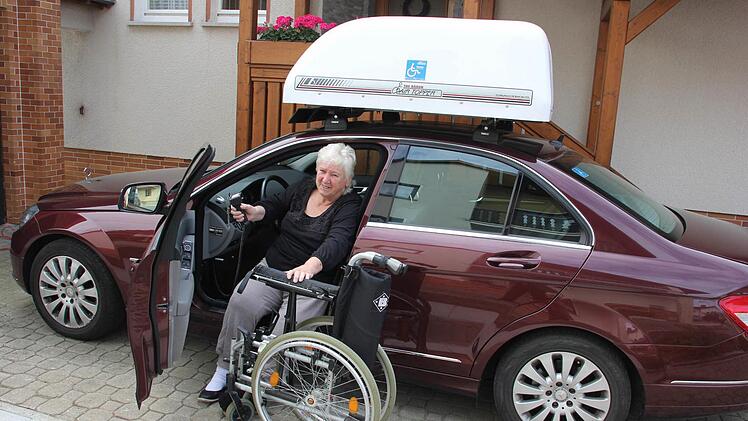 Erika Limmer hat auf dem Fahrersitz ihres Autos Platz genommen und den Rollstuhl gefaltet.  Foto: Friedwald Schedel