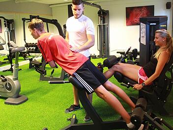 Tim Weimann (links) und Leni Schneider (rechts) testen schon einmal den neuen Fitness-Raum. Lorenz Beck (Mitte) kontrolliert die Haltung, damit die Übungen richtig ausgeführt werden. Foto: Carmen Schmitt