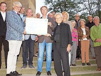 Der Lions-Club-Präsident Uwe Fischer (vorne, von links), der Fördervereinsvorsitzende Walter Mackert und Manfred Büdenbender überreichten Pfarrer Hans-Werner Alt einen Scheck über 4000 Euro für die Reinigungskosten der Banzer Orgel. Foto: Alfred Thieret