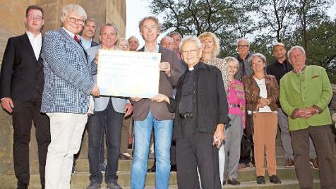 Der Lions-Club-Präsident Uwe Fischer (vorne, von links), der Fördervereinsvorsitzende Walter Mackert und Manfred Büdenbender überreichten Pfarrer Hans-Werner Alt einen Scheck über 4000 Euro für die Reinigungskosten der Banzer Orgel. Foto: Alfred Thieret