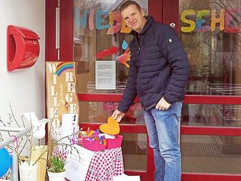 Pfarrer Andreas Krauter betrachtet den Tisch "to go" vor der Kita "Unterm Regenbogen".  Foto: Schülein