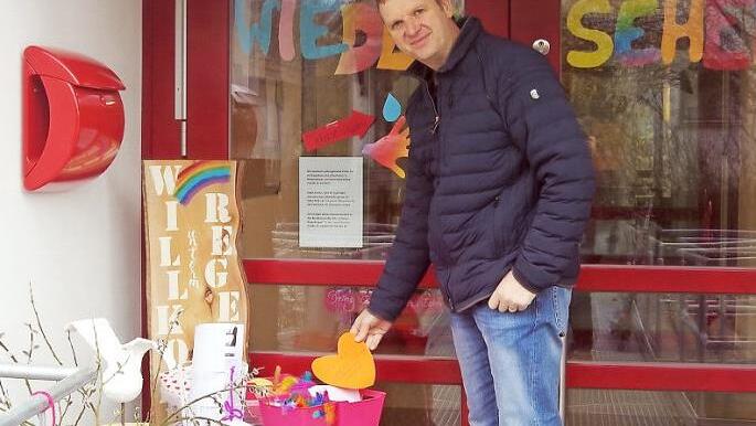 Pfarrer Andreas Krauter betrachtet den Tisch "to go" vor der Kita "Unterm Regenbogen".  Foto: Schülein