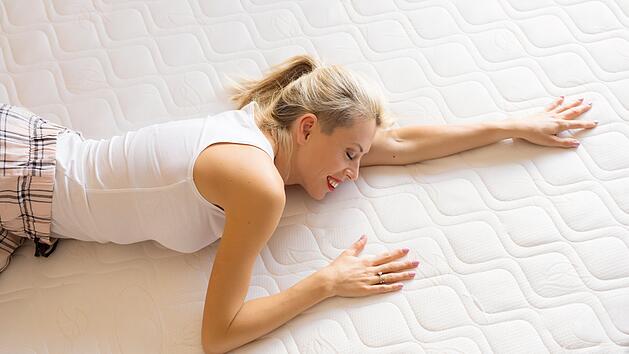 Frau genie&szlig;t ihre neue bequeme Matratze