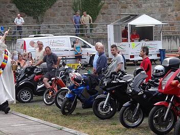 Diakon Sven Steffan segnet zum Ende des Gottesdienstes die Biker und ihre Maschinen. Foto:: Johanna Eckert
