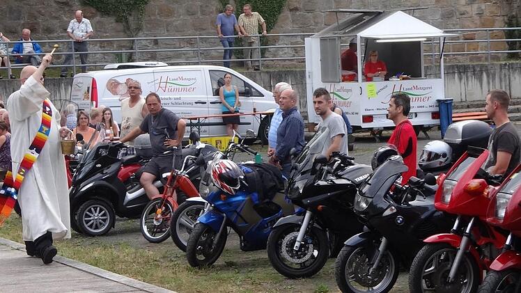 Diakon Sven Steffan segnet zum Ende des Gottesdienstes die Biker und ihre Maschinen. Foto:: Johanna Eckert