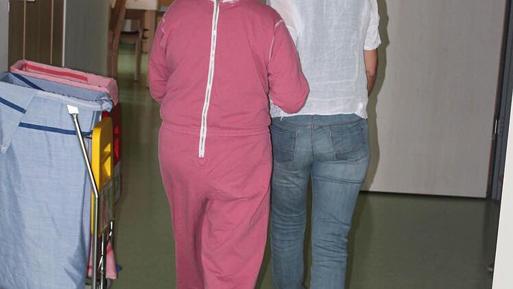Friederike Spörlein führt eine Bewohnerin durch die Gänge in ihr Zimmer. In diesen Momenten lässt sich etwas Verbundenheit seitens der Klienten erahnen.