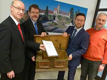 Bei der Übergabe der Stiftungsurkunde: Stephan Franke, Siegfried Wölki, Martin Finzel und Ulrich Platsch. Im Hintergrund das Ahorner Schloss, im Vordergrund die altehrwürdige Gemeindetruhe aus dem Jahr 1790  Foto: Lothar Weidner