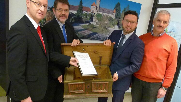 Bei der Übergabe der Stiftungsurkunde: Stephan Franke, Siegfried Wölki, Martin Finzel und Ulrich Platsch. Im Hintergrund das Ahorner Schloss, im Vordergrund die altehrwürdige Gemeindetruhe aus dem Jahr 1790  Foto: Lothar Weidner