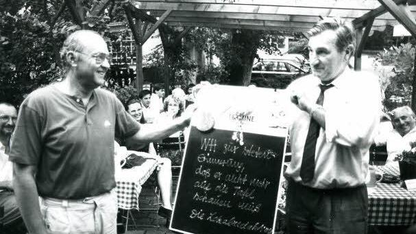 1989 verabschiedete sich Willy Heckel (rechts) im Gasthaus Heerlein von seinen Kollegen. Als Nachfolger überreichte ihm Rudolf Häußler (links) das Geschenk der Lokalredaktion: die alte Termintafel, die die Redaktionssekretärin früher täglich neu beschriftet hatte.  Foto: Archiv Emil Bauer