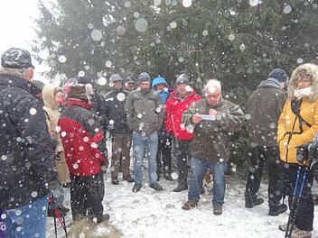 Rhönklub-Präsident Jürgen Reinhardt (mit dem Mikrofon) und Regionsvorsitzender Thomas Hammelmann (links daneben) eröffneten das Wanderjahr 2015 bei heftigem Schneetreiben auf dem Kreuzberg. Foto: Marion Eckert