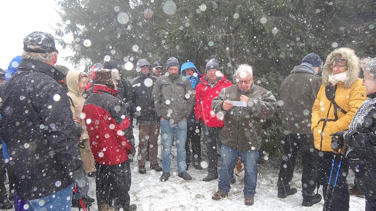 Rhönklub-Präsident Jürgen Reinhardt (mit dem Mikrofon) und Regionsvorsitzender Thomas Hammelmann (links daneben) eröffneten das Wanderjahr 2015 bei heftigem Schneetreiben auf dem Kreuzberg. Foto: Marion Eckert